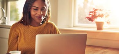 Young woman smiling at her laptop