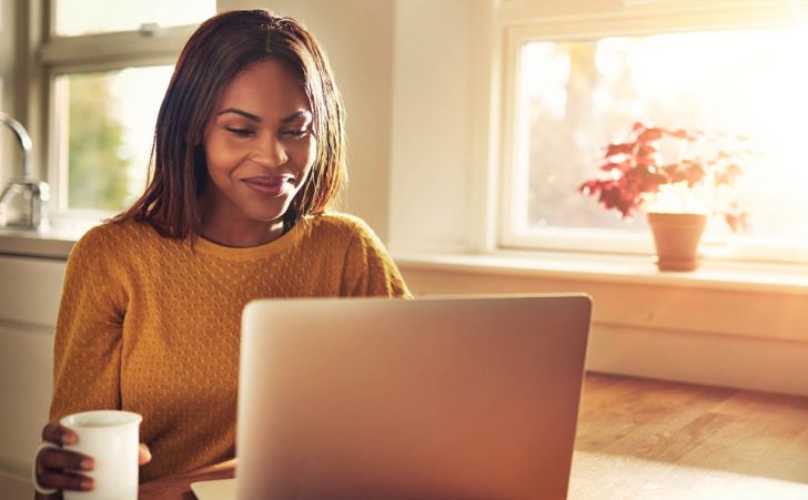 Young woman smiling at her laptop