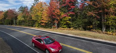 Red car driving down the road