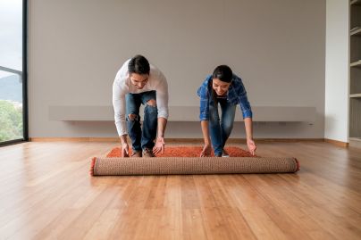 Couple rolling out rug on floor