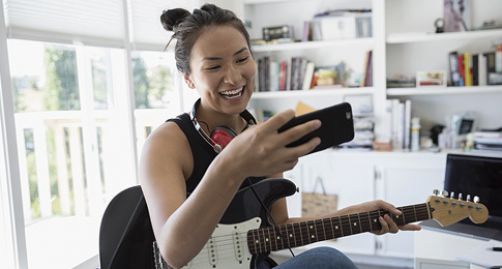 Student on her phone with a guitar