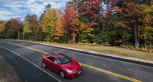 Red car driving down the road