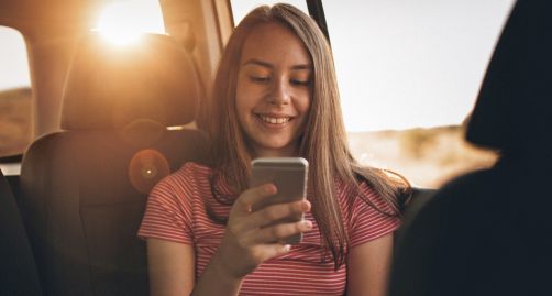 Girl looking at her phone in car