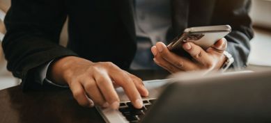 Male using his phone and laptop