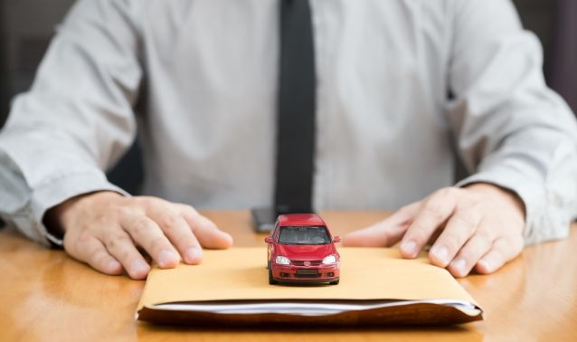 A miniature car on a folder of papers.