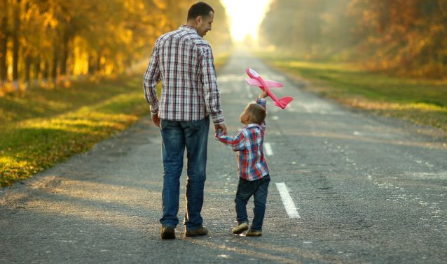 A father and son walking down a road.