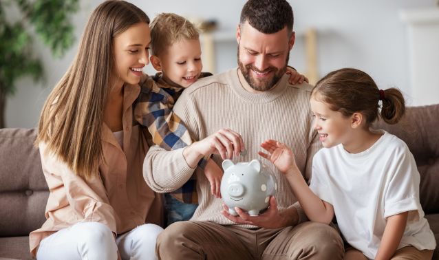 A family of four puts money into a piggybank.