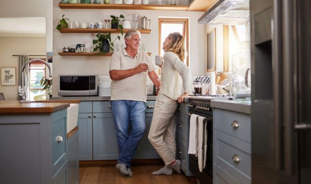 Couple standing in kitchen smiling