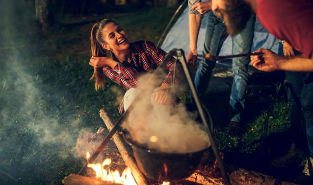 A group laughing around a campfire.