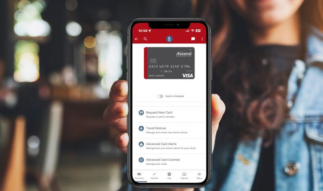 A woman holding a phone showing the Ascend app.