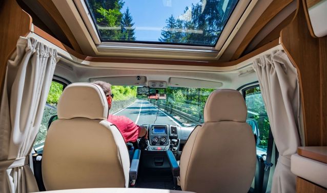 The inside of an RV with a man driving.