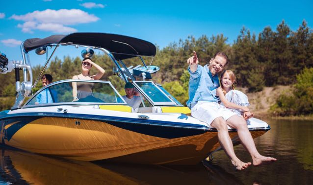 A father and daughter sitting on the front of a boat.