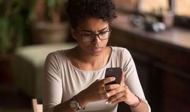 A woman looks at her phone.