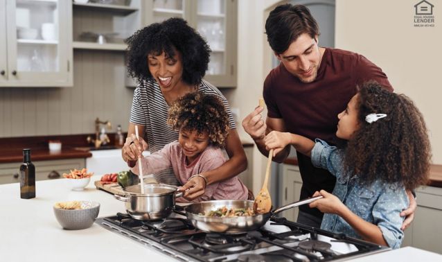 A family of four cooks dinner on a stovetop counter