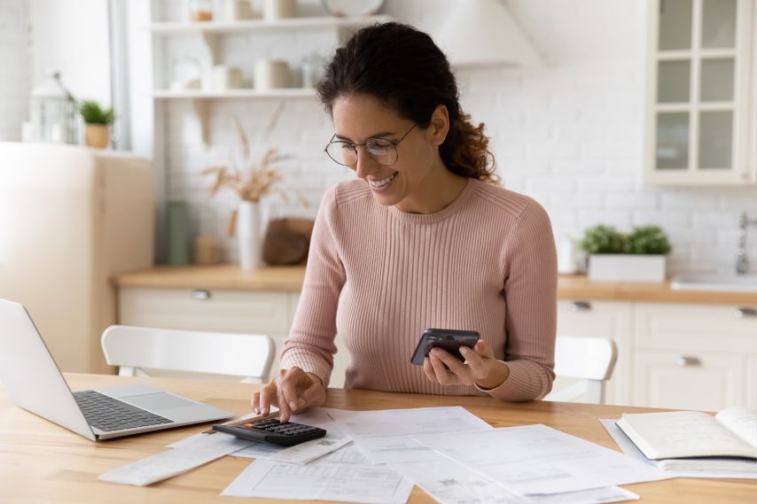 Woman using a calculator and laptop.