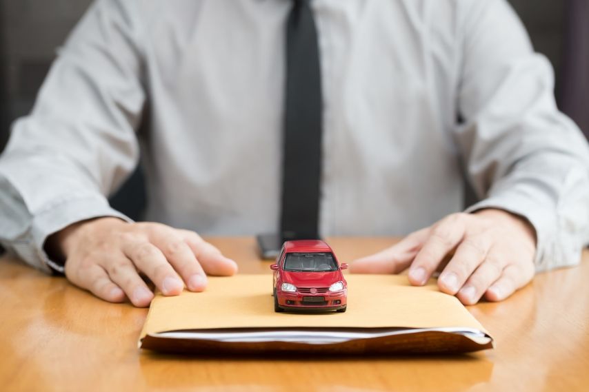 A miniature car on a folder of papers.