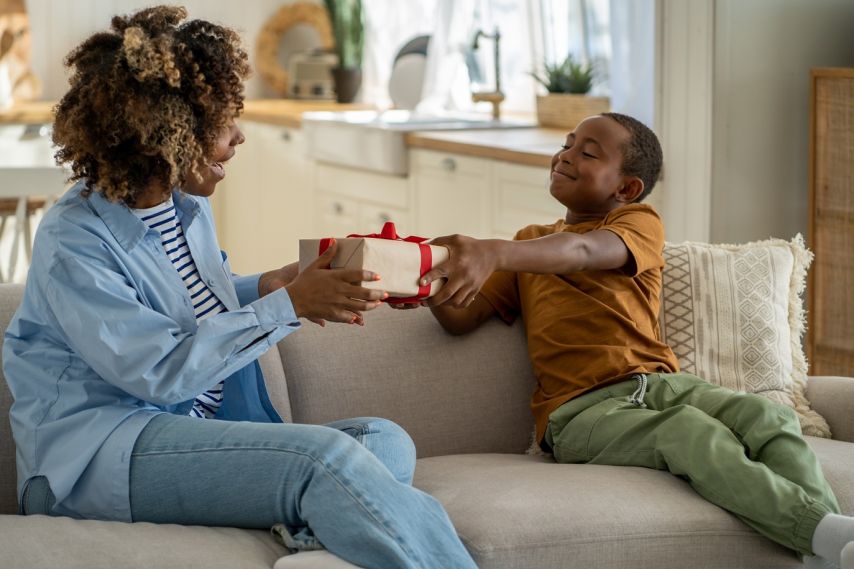 A child gives his mother a gift.