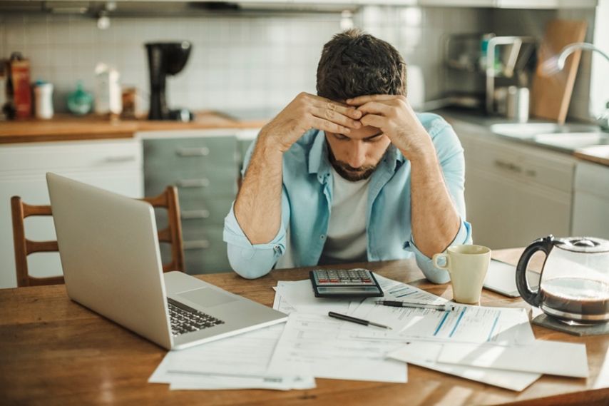 Man looks stressed while reviewing finances.