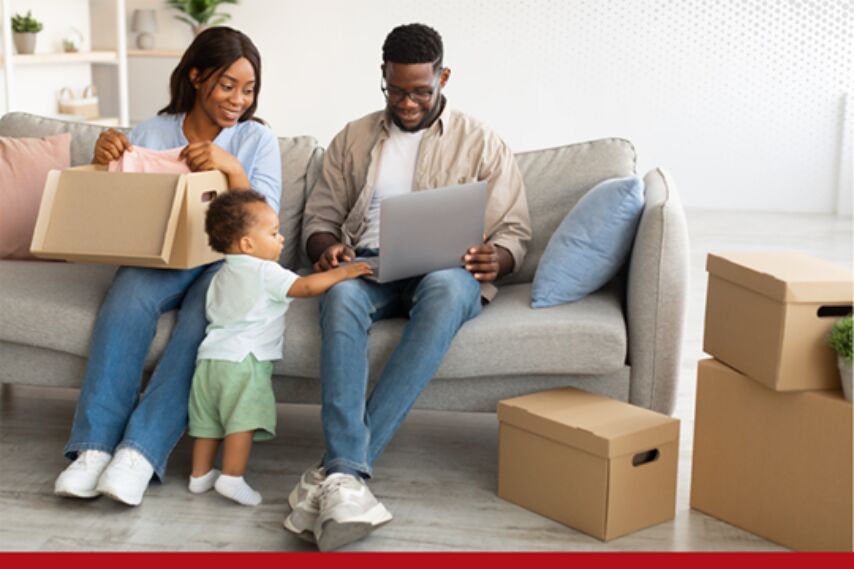 A man and woman joyfully let their child play on a laptop