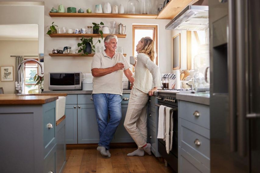 Couple standing in kitchen smiling