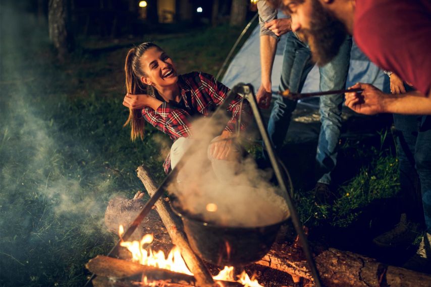 A group laughing around a campfire.