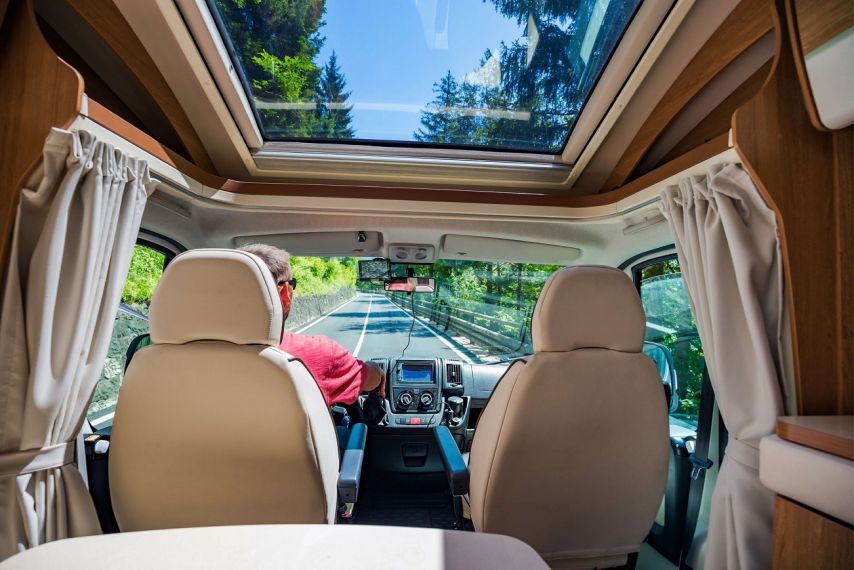 The inside of an RV with a man driving.