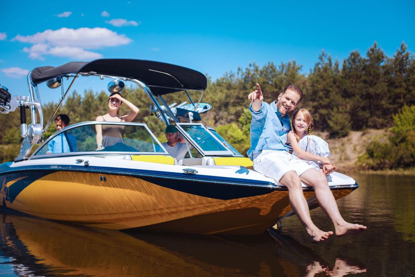 A father and daughter sitting on the front of a boat.