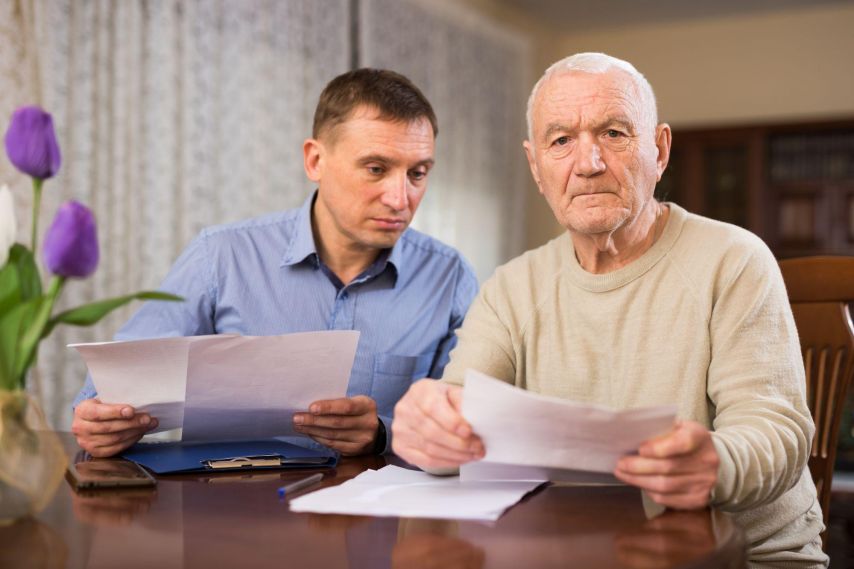 Two men reading over documents.