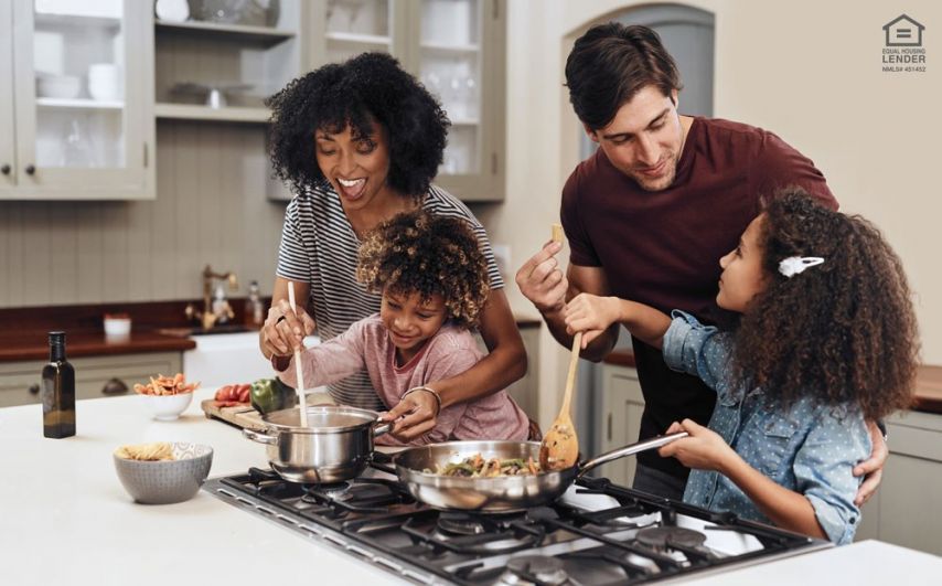 A family of four cooks dinner on a stovetop counter