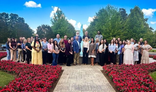 Ascend employees smile in front of fountain