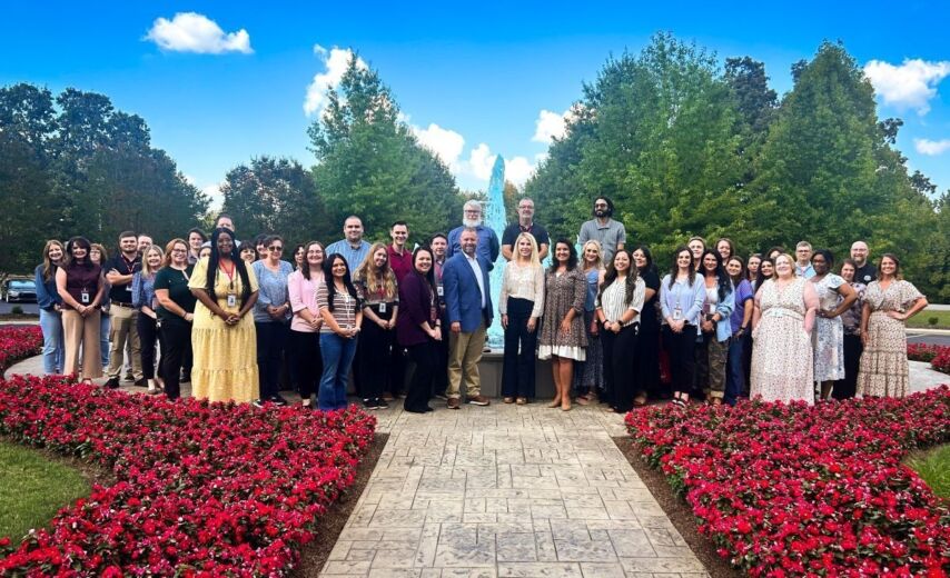 Ascend employees smile in front of fountain