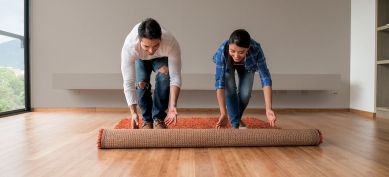 Couple rolling out floor rug