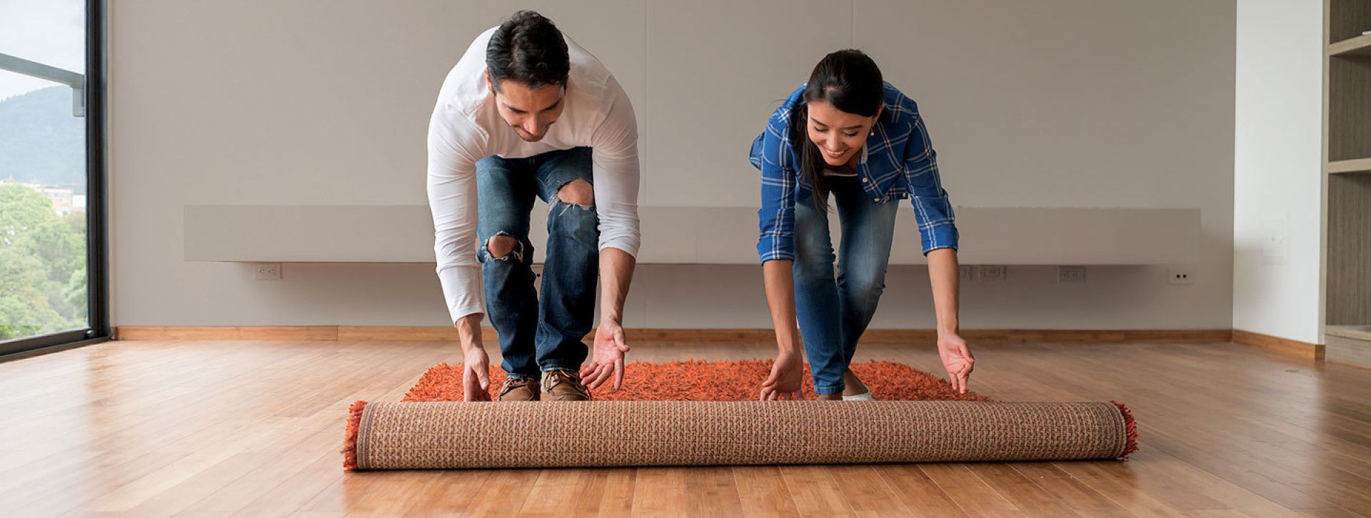 Couple rolling out floor rug