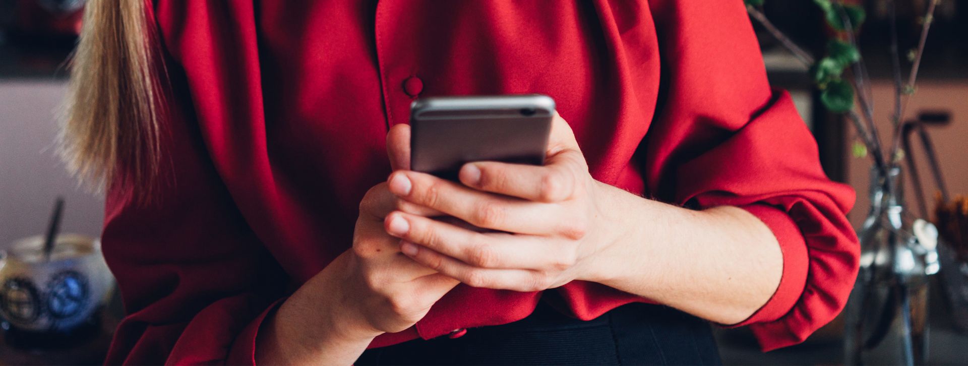 Woman in red blouse using phone