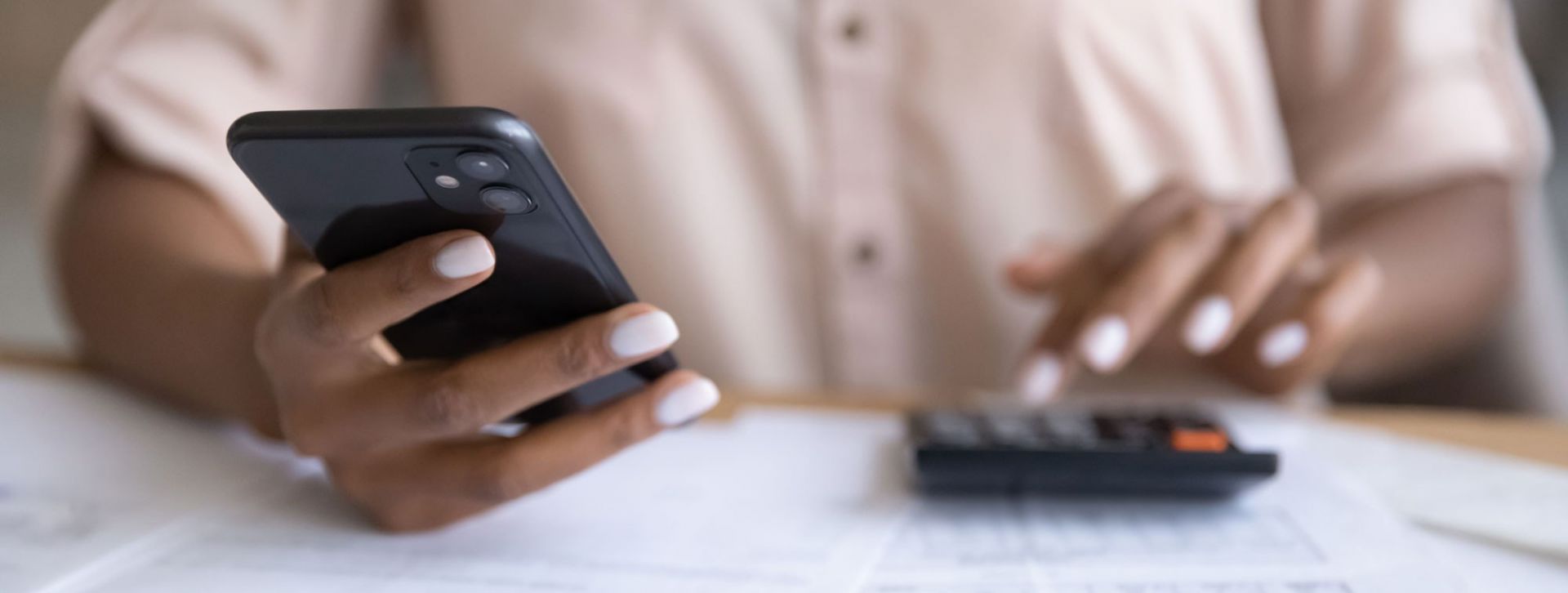 Woman using her phone and calculator